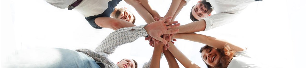 Menschen, die sich die Hände in der Mitte reichen und ein Team formen